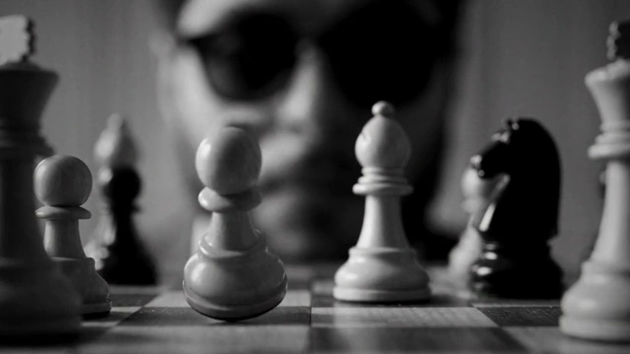 Gros plan sur des pièces d'échecs, un visage flou en arrière-plan, en noir et blanc.